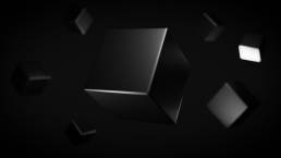 Abstract 3D rendered geometric shapes with a soft light against a dark background.